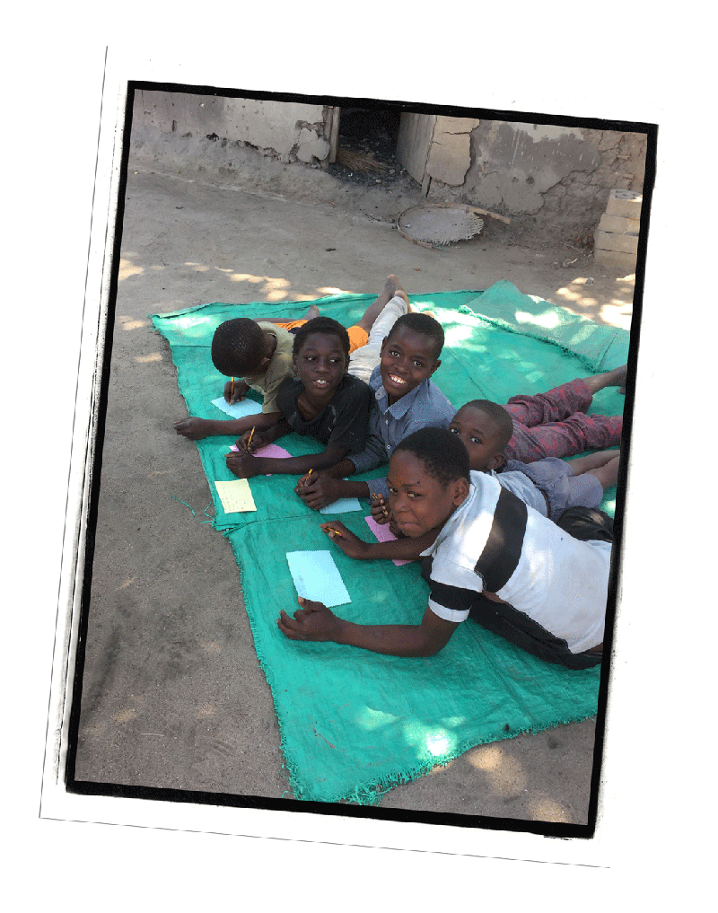 Kids writing letters on a blanket